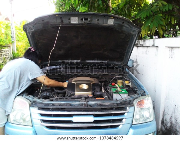 Blurry images, man, woman, check engine oil level,\
vehicle condition monitoring, engine maintenance And get ready\
before departure, engine maintenance concept. Ready to go. And\
travel
