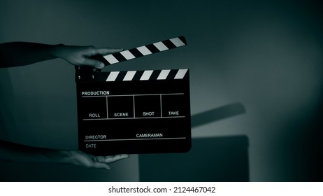 Blurry Images Of Movie Slate Or Clapper Board. Hand Holds Empty Film Making Clapperboard On Color Background In Studio For Film Movie Shooting Or Recording. 