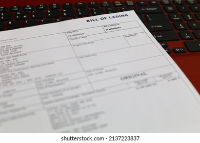 Blurry information of 'Original Bill of Lading' or BL is a document issued by a carrier (or their agent) to acknowledge receipt of cargo for shipment with keyboard laptop as background
