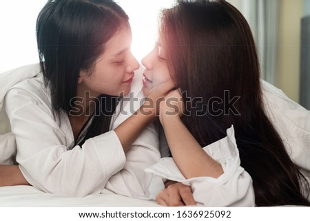 The blurry light design background of two beautiful women kissing together,with loved feeling,good friendship,roommate,best girlfriend,