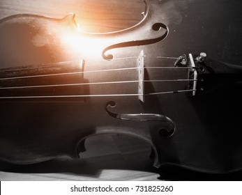 The blurry light design background of violin,string instrument put on wood board ,front side body,vintage tone,grainy film style,abstract art design.