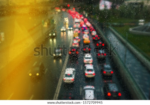 Blurry\
lights of high traffic cars. Bokeh Traffic on the highway in the\
city. Glowing lights. Bad weather for\
driving.