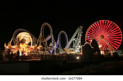 Blurry / long exposure image of a brightly lit amusement park rides - Powered by Shutterstock