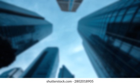 A blurry low angle perspective of tall corporate office buildings pointing towards the sky