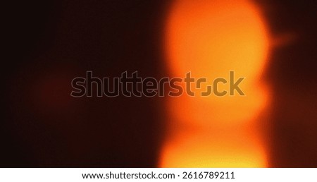 Blurry orange light leak effect on dark background. Abstract texture ideal for overlay.