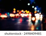 A blurry photo of a city street at night with lights from cars and motorcycles. Scene is busy and chaotic, with the lights from the vehicles creating a sense of movement and energy