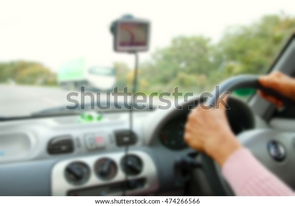 The blurry photo of control and\
dashboard and woman driver hand on steering represent the vehicle\
technology and transportation concept related\
idea.
