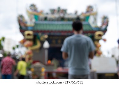 A Blurry Photo Of A Man Pay Respect To Shrine