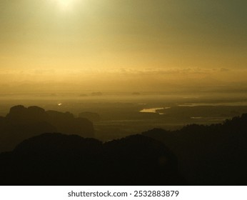 A blurry photo of a mountain range with a sunset in the background. The sky is a mix of orange and blue hues, creating a serene and peaceful atmosphere - Powered by Shutterstock