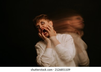 Blurry Portrait Of An Emotional Girl In A White Shirt On Dark Background