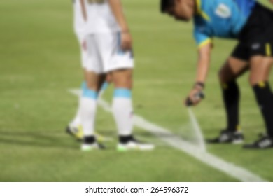 Blurry Referee  Marks Kick Off Positions With A Vanishing Spray 