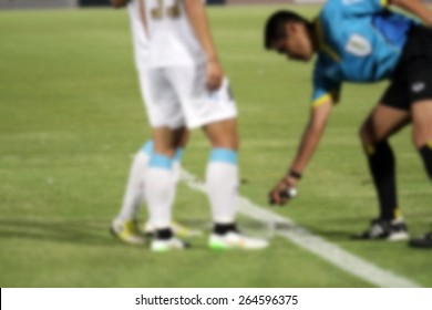 Blurry Referee  Marks Kick Off Positions With A Vanishing Spray 