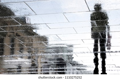 Blurry reflection shadow silhouettes of couple walking on dark rainy city street - Powered by Shutterstock