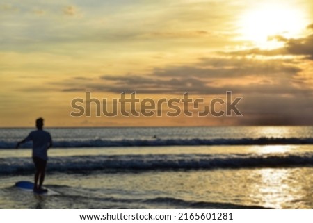 A blurry sea and surfer trying to steady on the surfboard