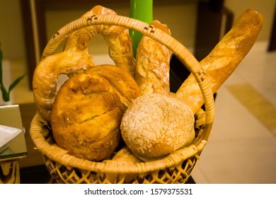 BLURRY and selective focus images of assorted breads put on the traditional bamboo basket.