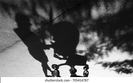 Blurry Shadow Of A Woman With Postpartum Depression Pushing A Baby Trolley On The Cracked Asphalt Suburban Park Road In Black And White