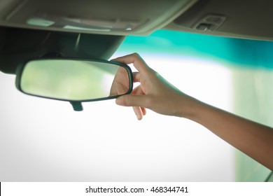 Blurry and soft focus of Asian women are adjusting the rearview mirror of the car