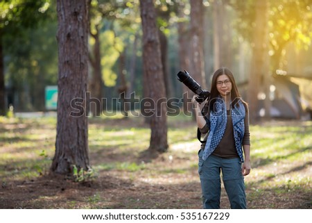 Blurry and soft focus of Women photographer holding a camera in the wild for take a photo.