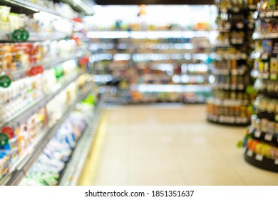 Blurry Supermarket Background, Grocery Store Aisle With Food Products On Shelves. Abstract Blurred Defocused Shot Of Groceries Shop With No Customers, Shopping Concept.