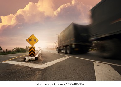 Blurry Truck With Fork In The Road Sign.