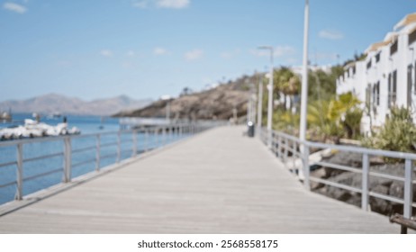 Blurry view of a defocused marina walkway with yachts in the background and a scenic coastal landscape under a clear sky - Powered by Shutterstock - Get 15% off with code: PIKWIZARD15