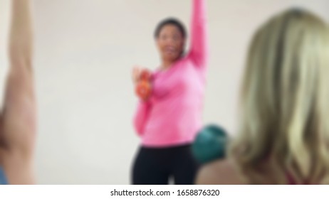 Blurry View Of Instructure Leading Stretching Before Entering Core Exercise At The Gym