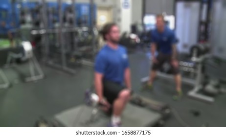 Blurry View Of Instructure Leading Stretching Before Entering Core Exercise At The Gym