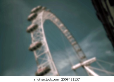 A blurry view of a large white Ferris wheel partially obscured by a building. - Powered by Shutterstock