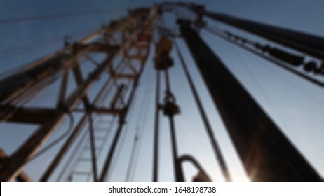 Blurry View Of Oil Workers Check Oil Pump. Roustabouts Doing Dirty And Dangerous Work On An Oil Well Servicing Rig.