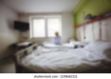 Blurry View Of Patient Sitting On Hospital Bed