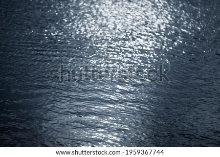 Blurry water wave ripple with  bright abstract bokeh of sun ligh.Nature background.