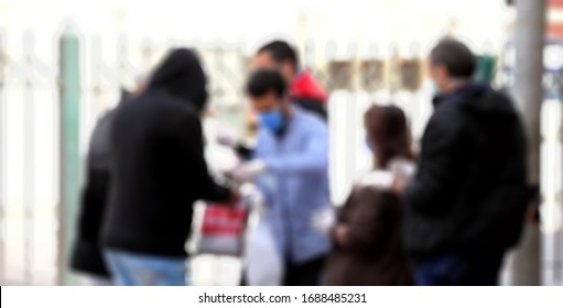 A Blurry Young Man Is Helping Old People To Wear Masks As An Effort To Prevent The Spread Of The Corona Virus( COVID 19).