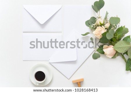 Blush wedding bouquet with roses, wedding envelopes and silk ribbons on white background