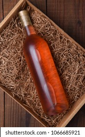 Blush Wine Bottle In Packing Straw: High Angle Shot Of A Single Bottle In A Cardboard Box With Straw Packing.