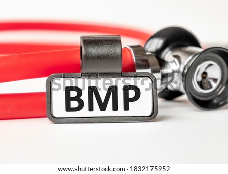 BMP: Basic metabolic panel lettering on a business card with a holder, next to the red stethoscope. Medical concept. Treatment and prevention. Human health.