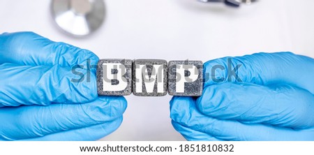 BMP Basic metabolic panel - word from stone blocks with letters holding by a doctor's hands in medical protective gloves