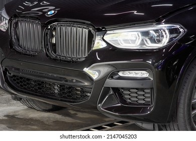 The BMW Car, Covered With A Protective Shiny Black Paint Film, Is In A Repair Shop. PPF Polyurethane Film Protects Car Paint From Stones And Scratches, Blurred Focus. Chelyabinsk, Russia, May 07, 2021