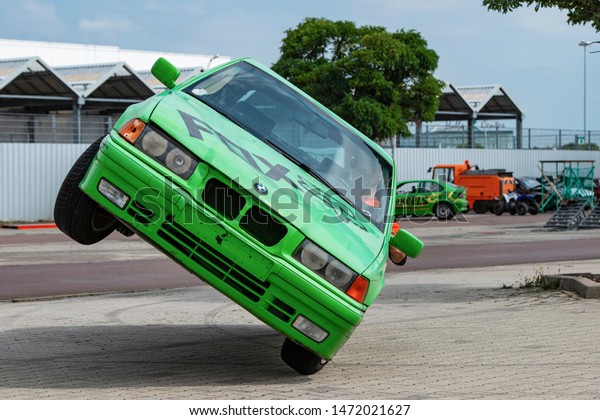 BMW car rides sideways\
on two wheels, at an auto show in the city of Halle (Saale),\
Germany, 04.082019