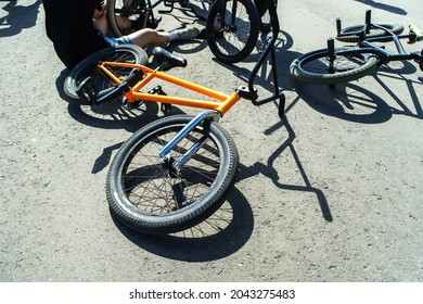 BMX bicycles for sports performances lie on the asphalt. Preparing for the competition and checking for faults. Foreground