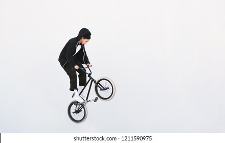 BMX freestyle. Young BMX bicycle makes tricks on the white background. Copyspace7 Bmx trick on a white background - Powered by Shutterstock