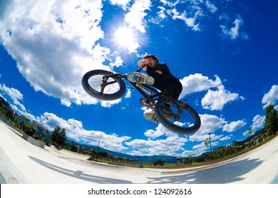 BMX Rider Jumps While Doing Cross Bar Trick.