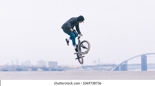 BMX rider makes a TAilwhip trick. Young man doing tricks in the air on a BMX bike. BMX freestyle