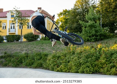 BMX rider performing aerial trick. Skilled BMX freestyler jumping over skatepark ramp. - Powered by Shutterstock