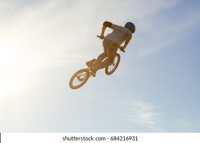 Bmx rider performing a tail whip at a quarter pipe ramp on a skatepark - Powered by Shutterstock