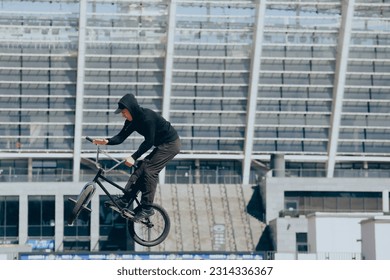 BMX rider performs tricks on street - Powered by Shutterstock