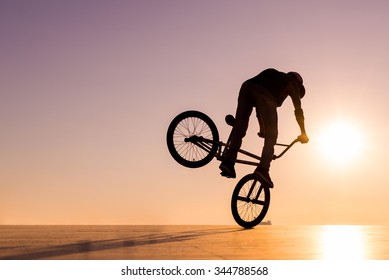 BMX silhouette rider at sunset 
