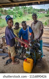 Bo, Sierra Leone - January 19, 2014: Group Of Unidentified Young African Mechanics Operating Diesel Generator