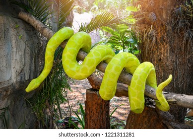 boa snake statue / the big green boa on tree branch on nature park
