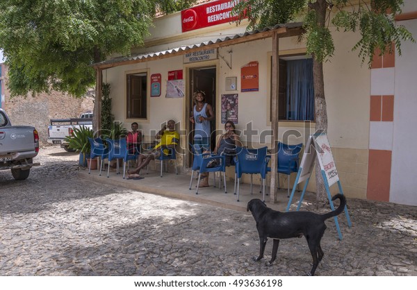 BOA VISTA, CAPE\
VERDE - AUGUST 30, 2015: A group of friends drinking beer in a bar\
in the town of Figueiras