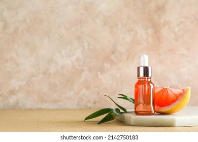 Board With Bottle Of Grapefruit Essential Oil On Color Background